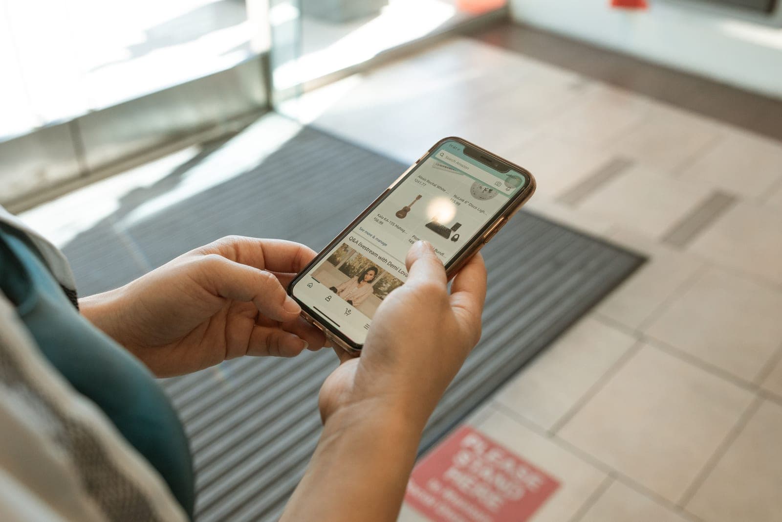 A person holding a smartphone showing a shopping app