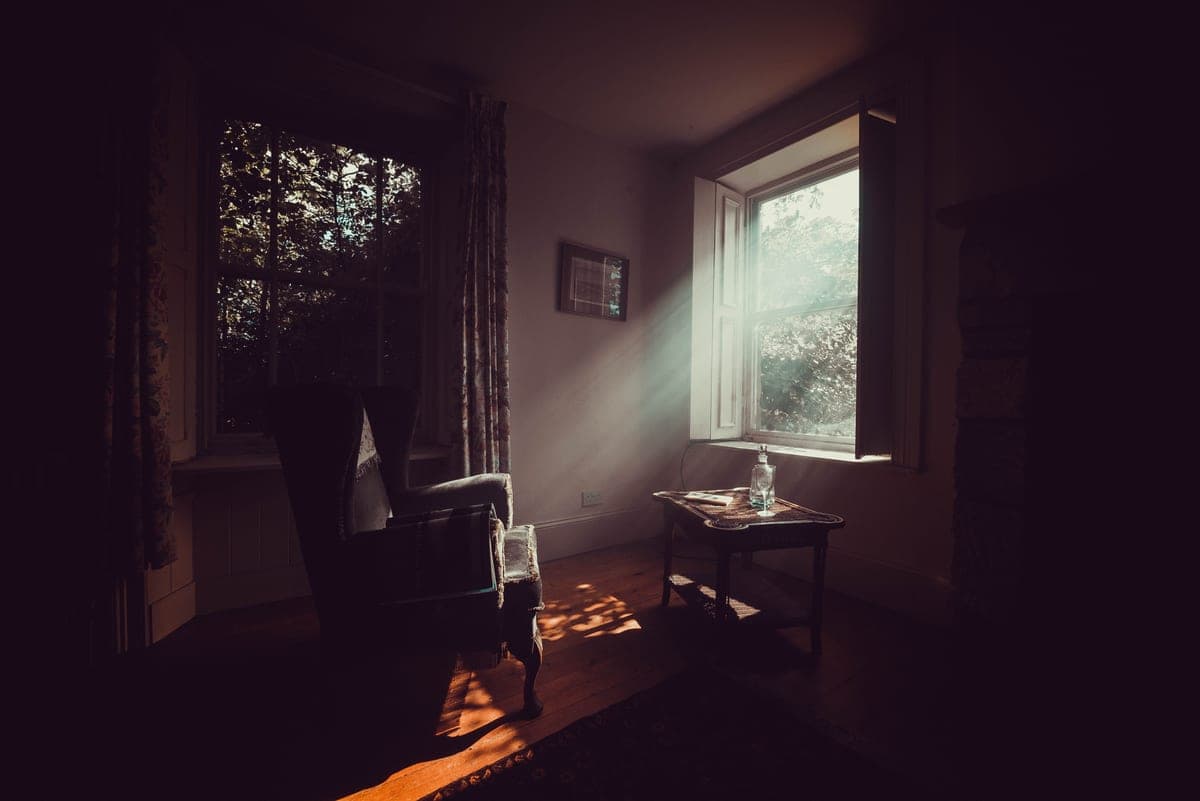 Sunlight falling across a quiet living room with vintage furniture
